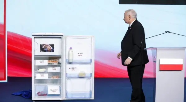 Otwarta lodówka z produktami i etykietami wzrostu cen, obok polityk. Ilustracja programu gospodarczego PiS a realia inflacji.
