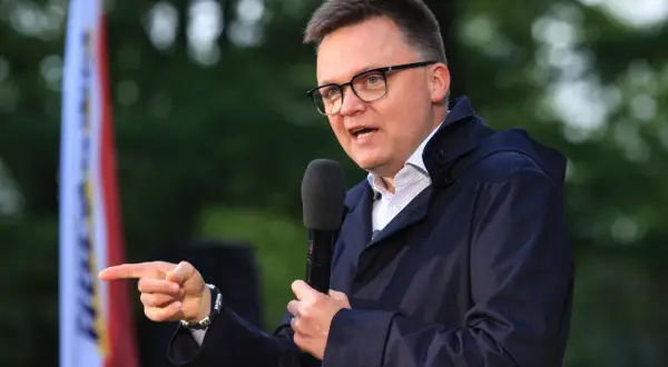 Mężczyzna w okularach przemawia do mikrofonu, wskazując palcem. Czy to przyszła struktura elektoratu polska 2050? Kto głosuje na Hołownię?