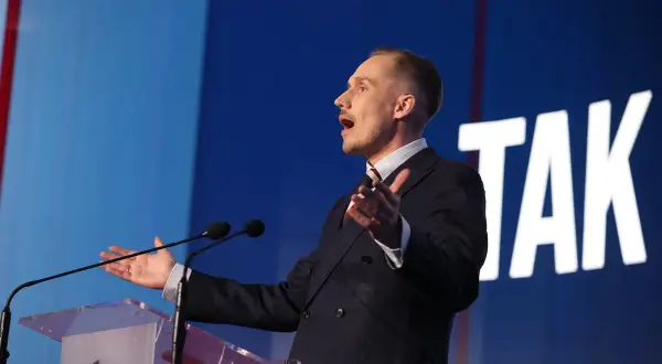 Poseł Konfederacji z mównicą, gestykuluje, mówiąc o bonie zdrowotnym.