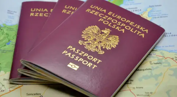 Trzy polskie paszporty leżą na mapie. Zastanawiasz się, ile się czeka na paszport?