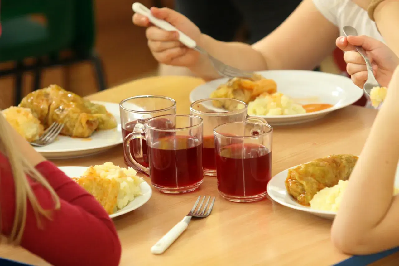 Dzieci jedzą bezpłatne posiłki w szkole. Koszty programu lewicy obejmują takie obiady, jak gołąbki z ziemniakami i kompot.