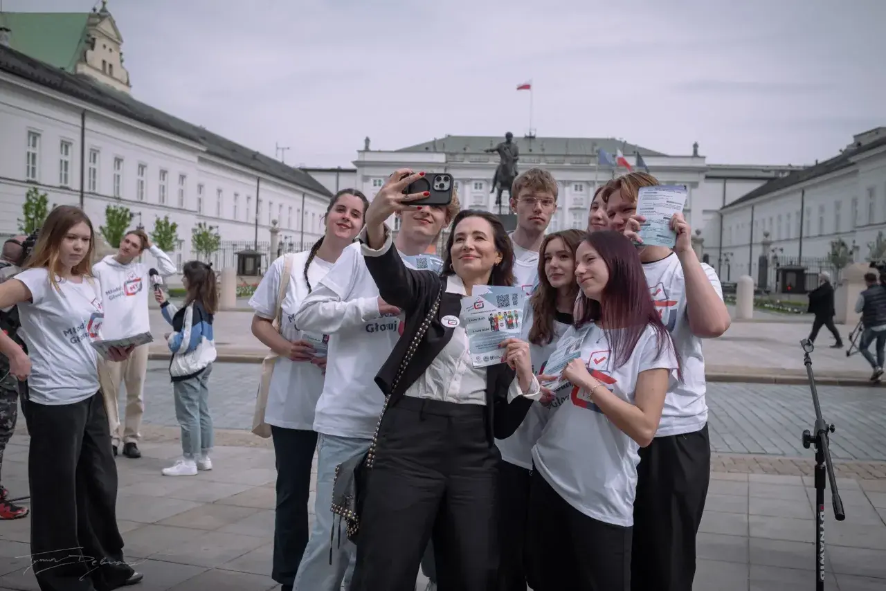 Młodzi ludzie z ulotkami "Młodzi Głosują" robią sobie selfie pod Pałacem Prezydenckim. Czy to odpowiedź na pytanie, dlaczego młodzi ludzie rzadko głosują na PiS?