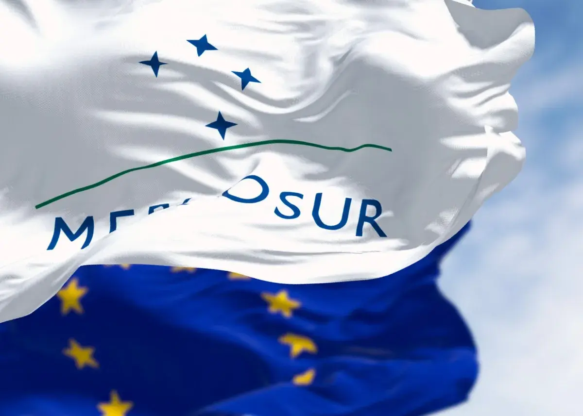 Flaga Mercosur, symbol współpracy gospodarczej, powiewa na tle błękitnego nieba.