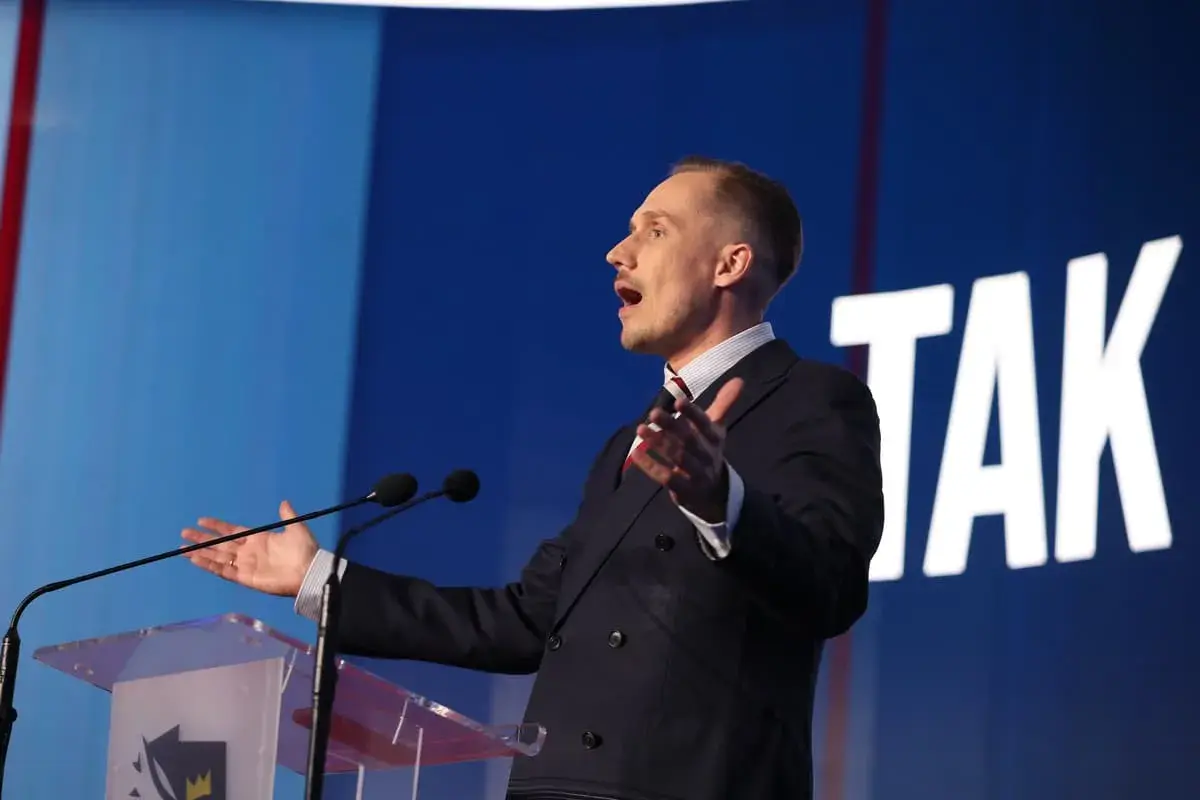 Poseł Konfederacji z mównicą, gestykuluje, mówiąc o bonie zdrowotnym.