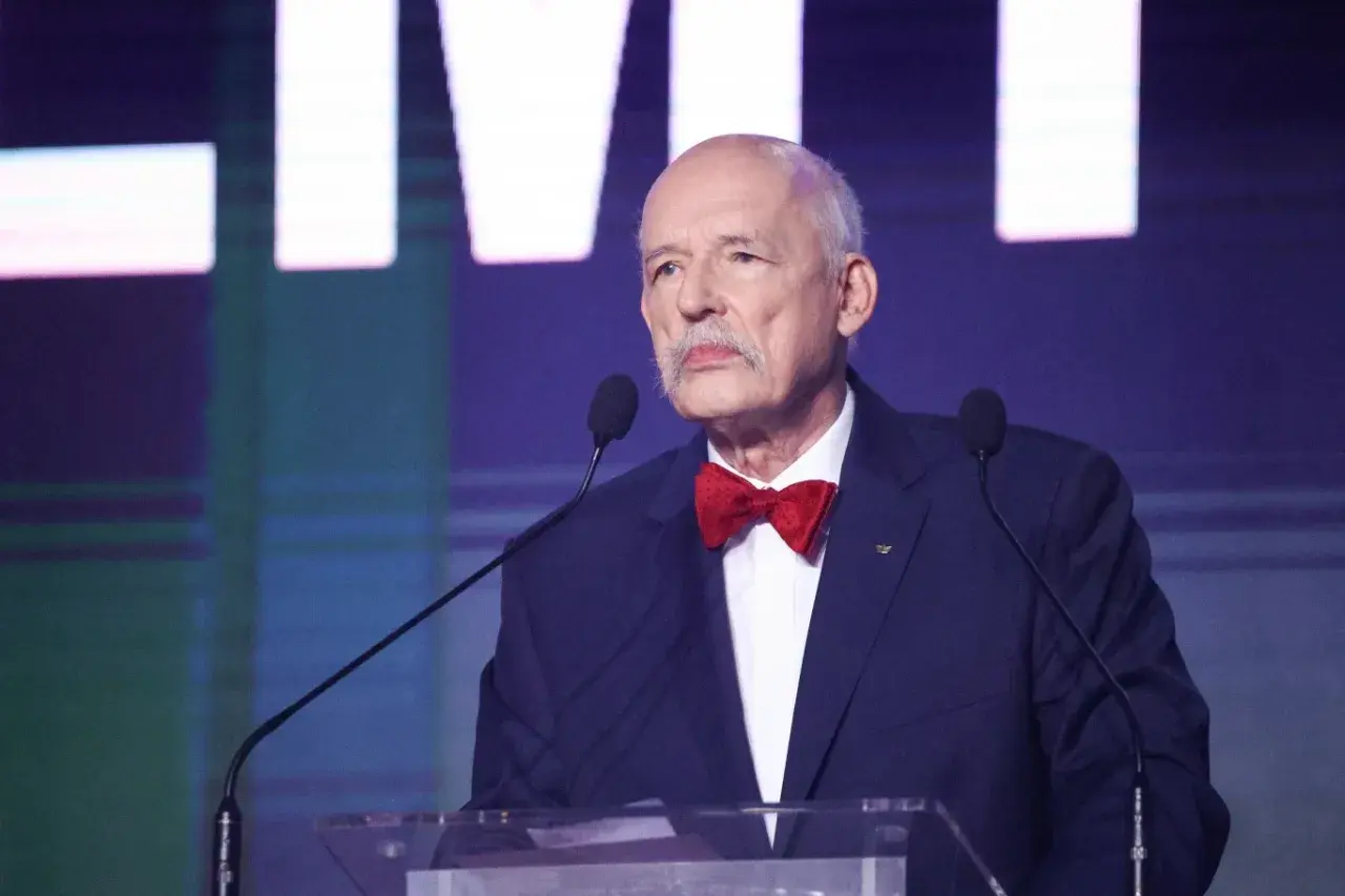 Janusz Korwin-Mikke, w muszce, przemawia. Jego kontrowersyjne wypowiedzi często prowadziły do pytań, dlaczego został odsunięty od władzy.