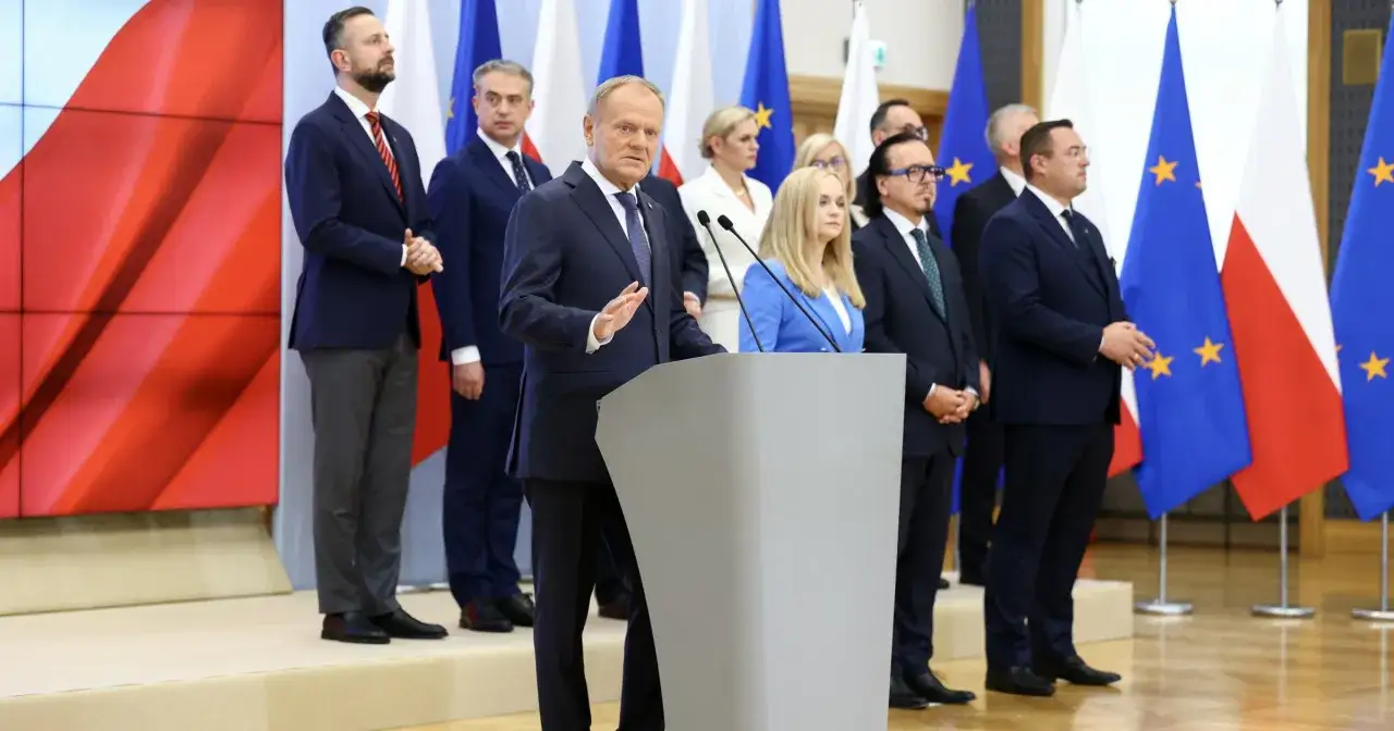 Donald Tusk przemawia, obok politycy Koalicji Obywatelskiej. Różnice w polityce socjalnej między KO a PiS są kluczowe dla przyszłości Polski.