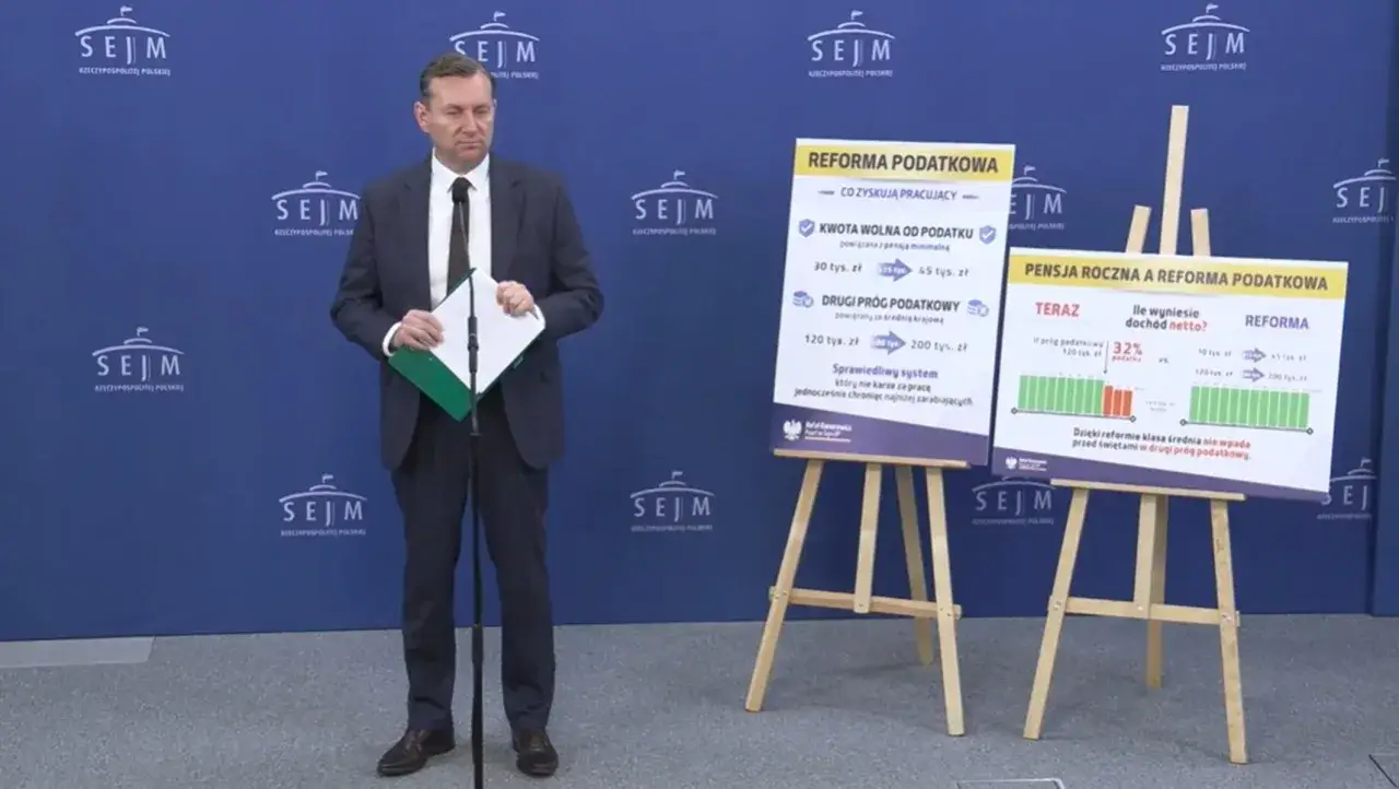 Mężczyzna w garniturze prezentuje reformę podatkową. Czy Polska 2050 popiera podatek katastralny? Nie ma o tym wzmianki.