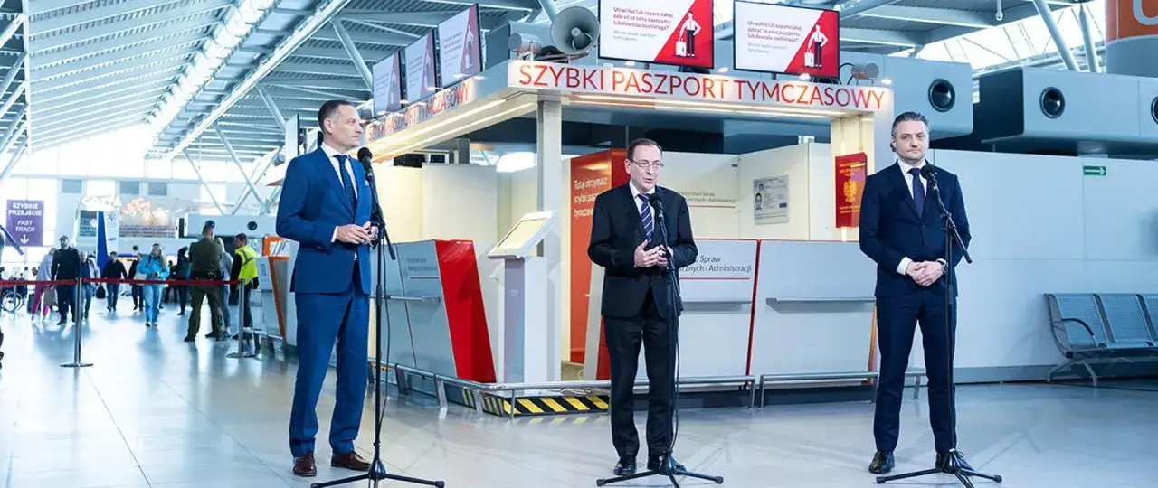 Dwóch mężczyzn w garniturach przemawia przy stanowisku 