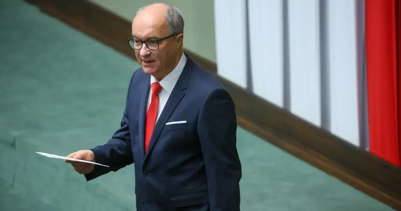 Włodzimierz Czarzasty syn, w granatowym garniturze i czerwonym krawacie, trzyma kartkę.