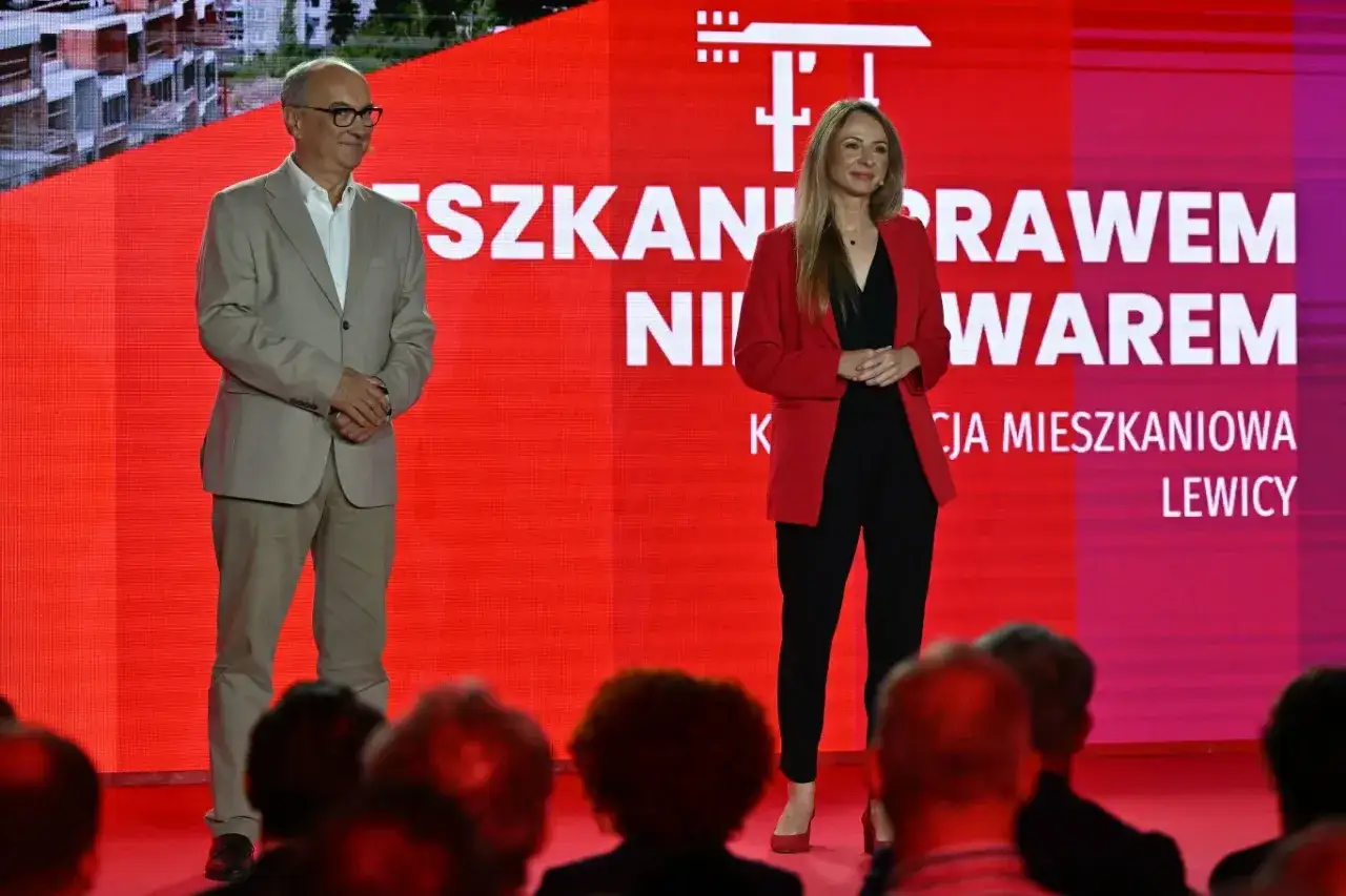Dwoje polityków na tle hasła 