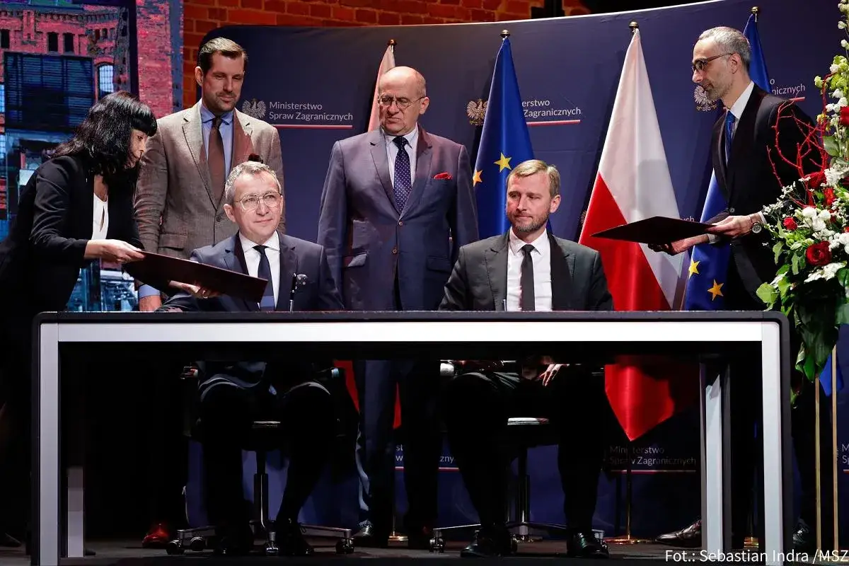 Afera wizowa rządu PiS: podpisanie dokumentów przez polityków. Tło z flagami i logo MSZ.