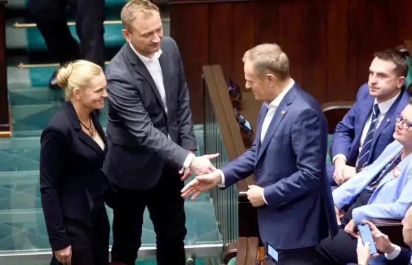 Maciej Rembarz, partner Barbary Nowackiej, wita się z Donaldem Tuskiem w Sejmie.