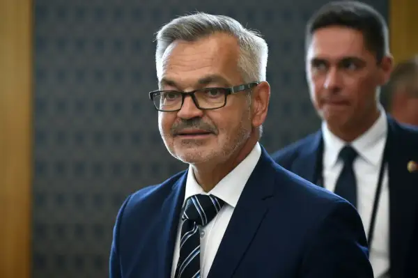 Mężczyzna w okularach, w granatowym garniturze i krawacie, przypomina ambasadora Rosji.