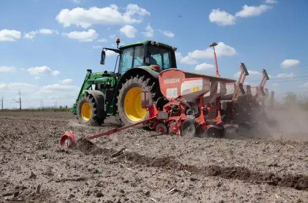 Traktor sieje na polu. Koalicja Obywatelska obietnice dla rolników a rzeczywistość – ciężka praca na roli trwa.