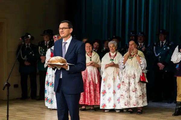 Mateusz Morawiecki z bochenkiem chleba, w otoczeniu osób w strojach ludowych. Kto zyskał najwięcej na rządach prawa i sprawiedliwości?