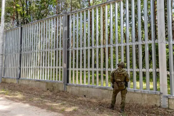 Strażnik graniczny przy płocie z drutem kolczastym. Nowa polityka migracyjna rządu koalicji obywatelskiej na granicy z Białorusią.