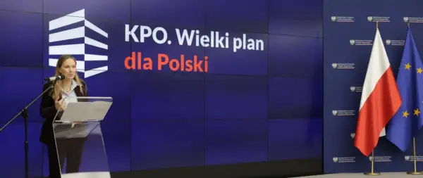Kobieta przemawia na tle hasła "KPO. Wielki plan dla Polski". Koalicja Obywatelska walczy o odblokowanie środków z KPO.