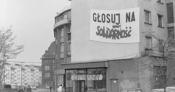 Transparent baner "Głosuj na Solidarność" na budynku, symboliczny protest przeciwko komunizmowi.