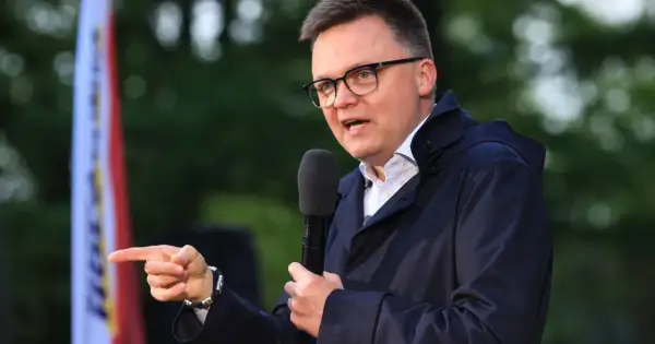Mężczyzna w okularach przemawia do mikrofonu, wskazując palcem. Czy to przyszła struktura elektoratu polska 2050? Kto głosuje na Hołownię?