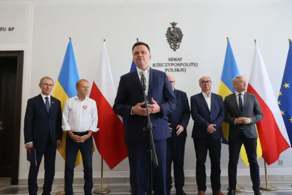 Pakt senacki: jak lewica negocjowała miejsca na listach wyborczych. Politycy stoją przed flagami Polski i Ukrainy.